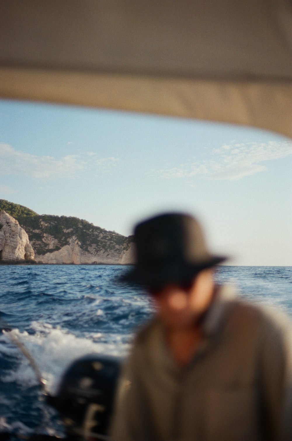 ein Mann mit Hut auf einem Boot im Ozean
