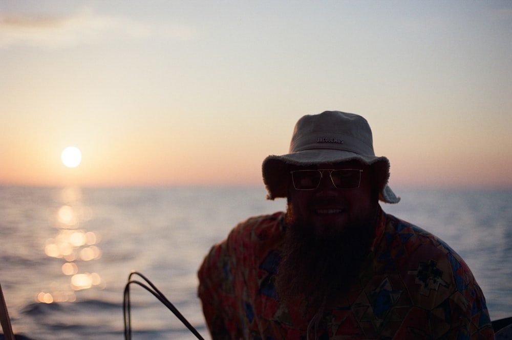 a man wearing a hat and sunglasses on a boat