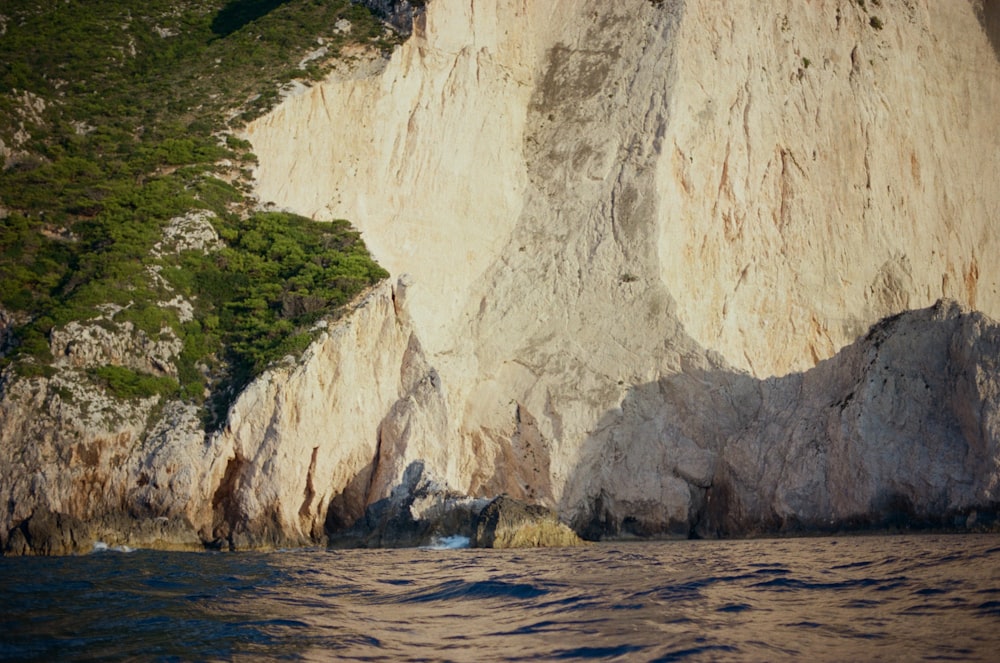 a large rock formation next to a body of water