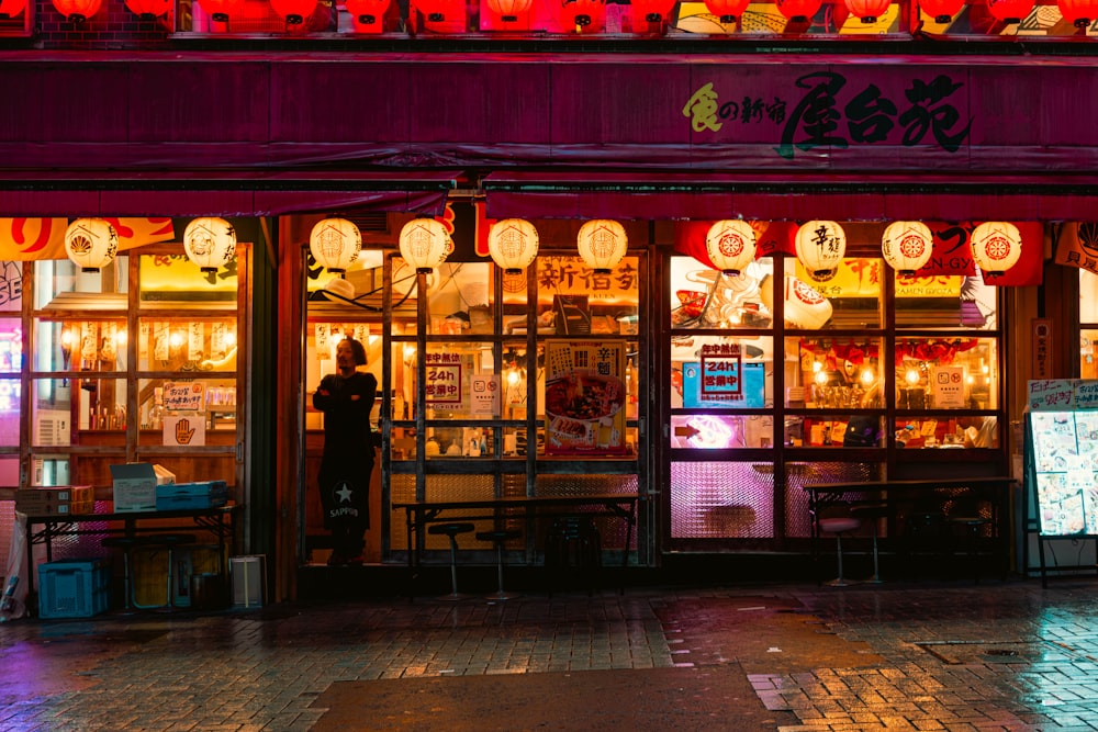 a person standing outside of a store at night