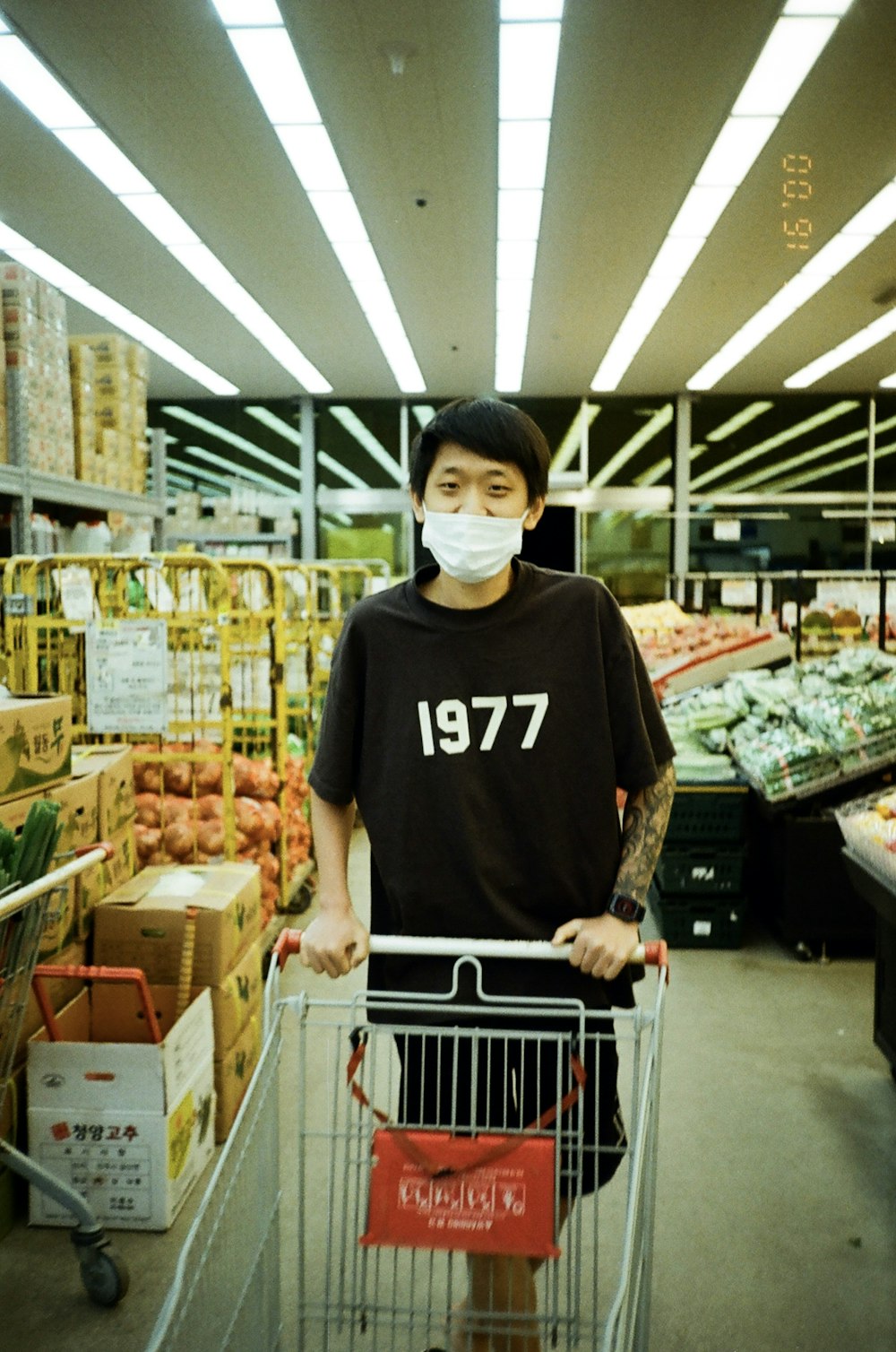 a man with a face mask standing in a grocery store