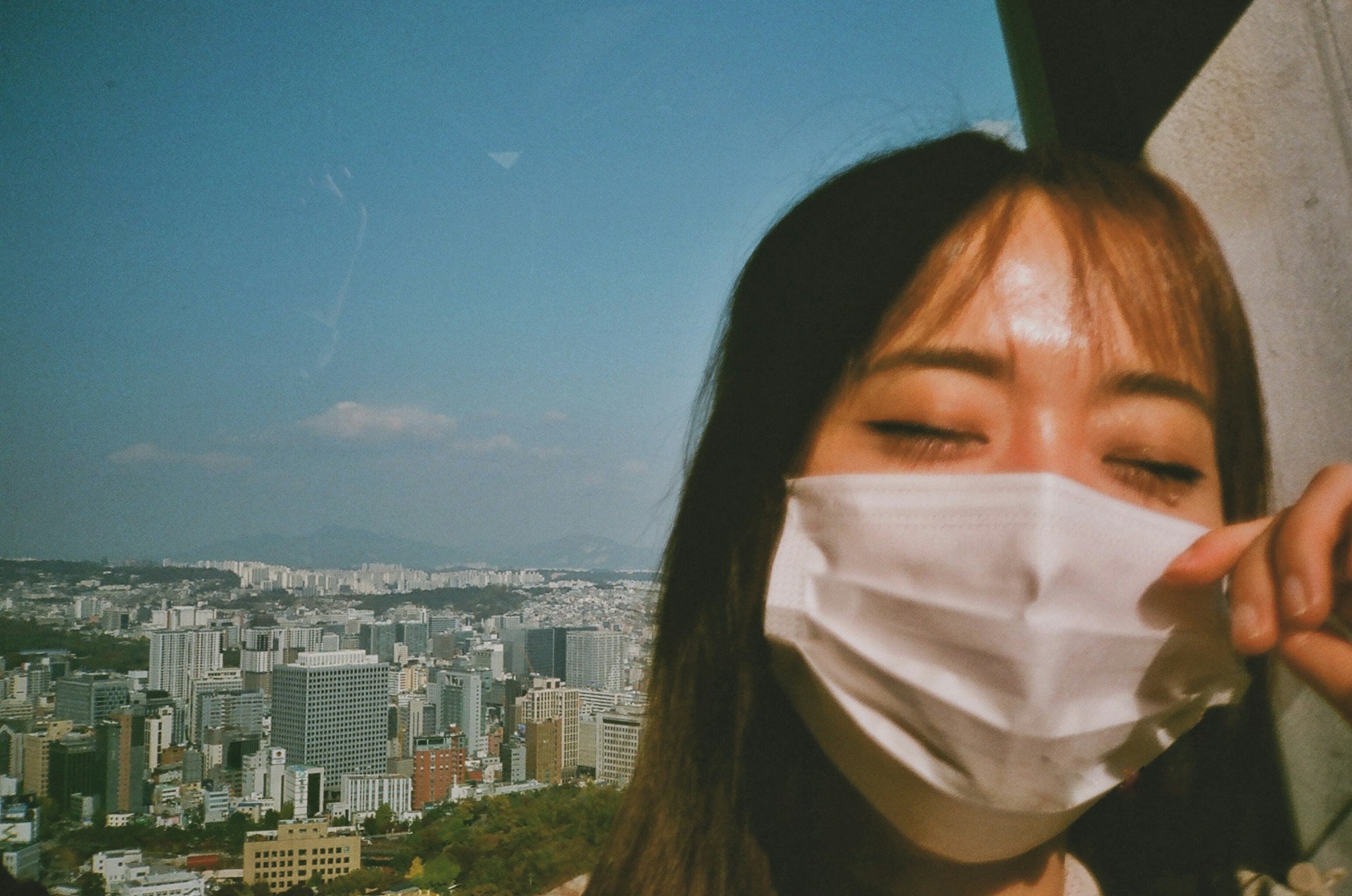 a woman wearing a face mask in front of a cityscape