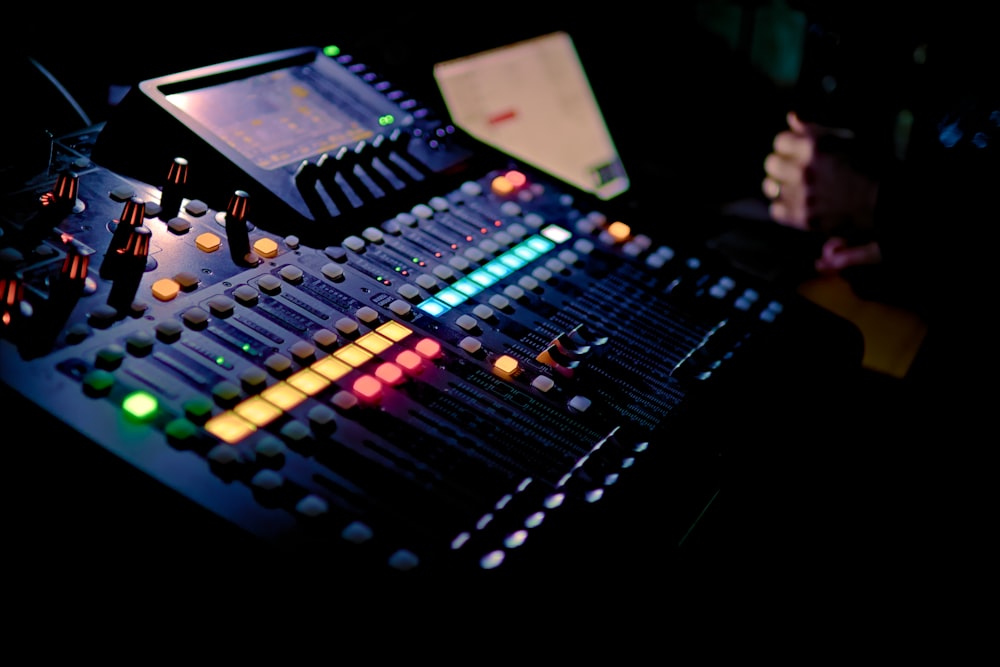 a sound mixing console in a dark room