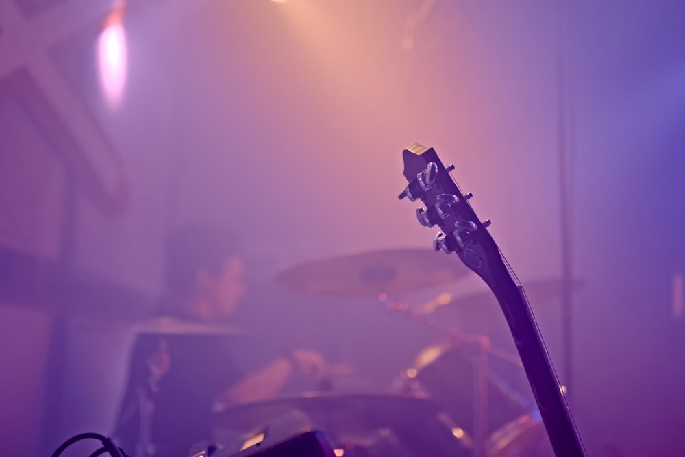 a man playing a guitar in front of a drum set