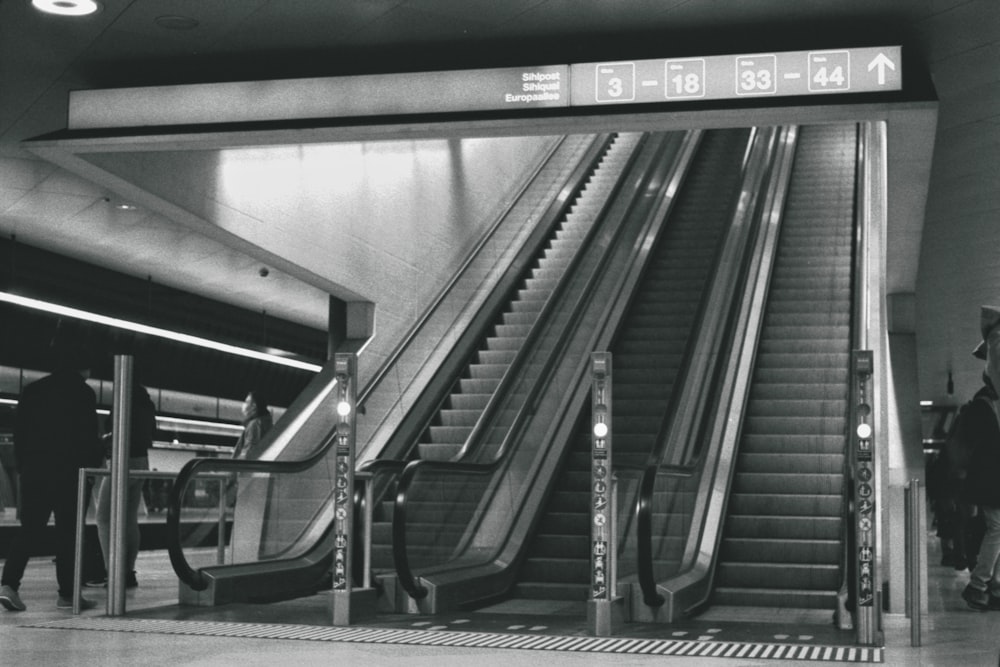 a black and white photo of an escalator