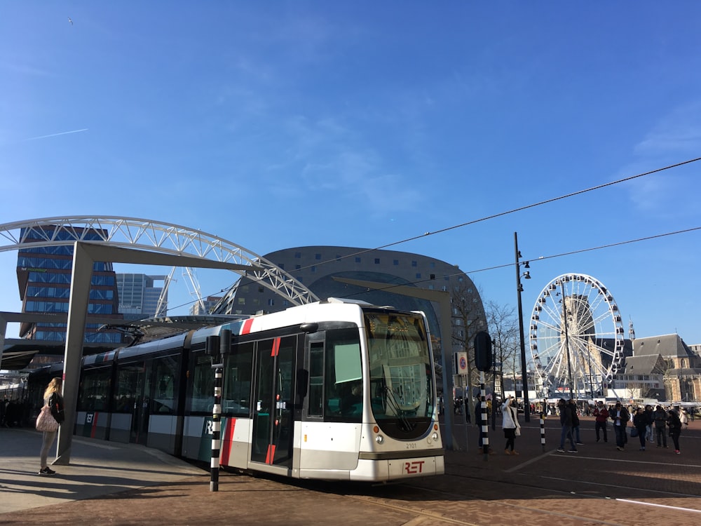 Ein Bus, der vor einem Gebäude parkt, mit einem Riesenrad im Hintergrund