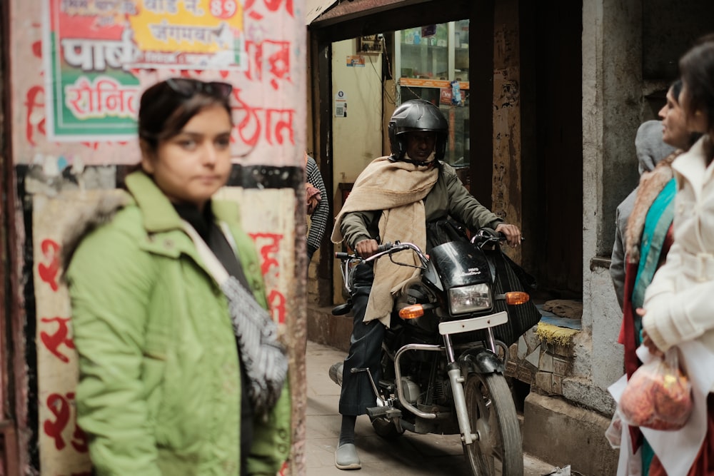 a woman riding a motorcycle down a street