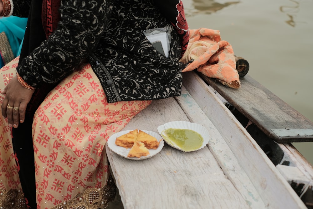 a woman sitting on a boat with a plate of food