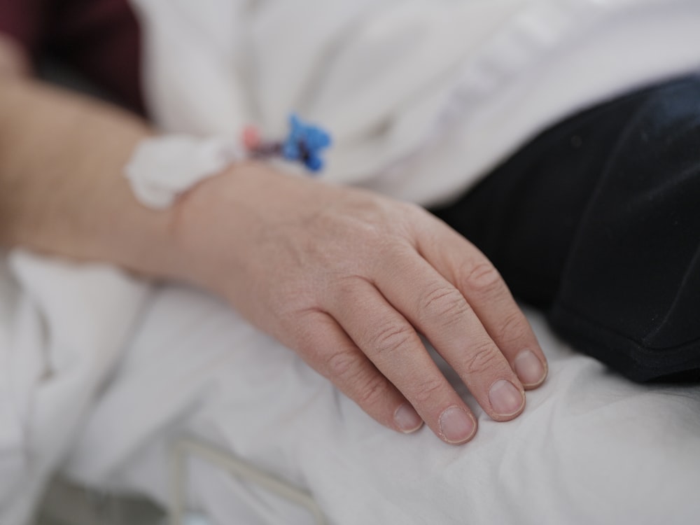 a close up of a person's hand on a bed