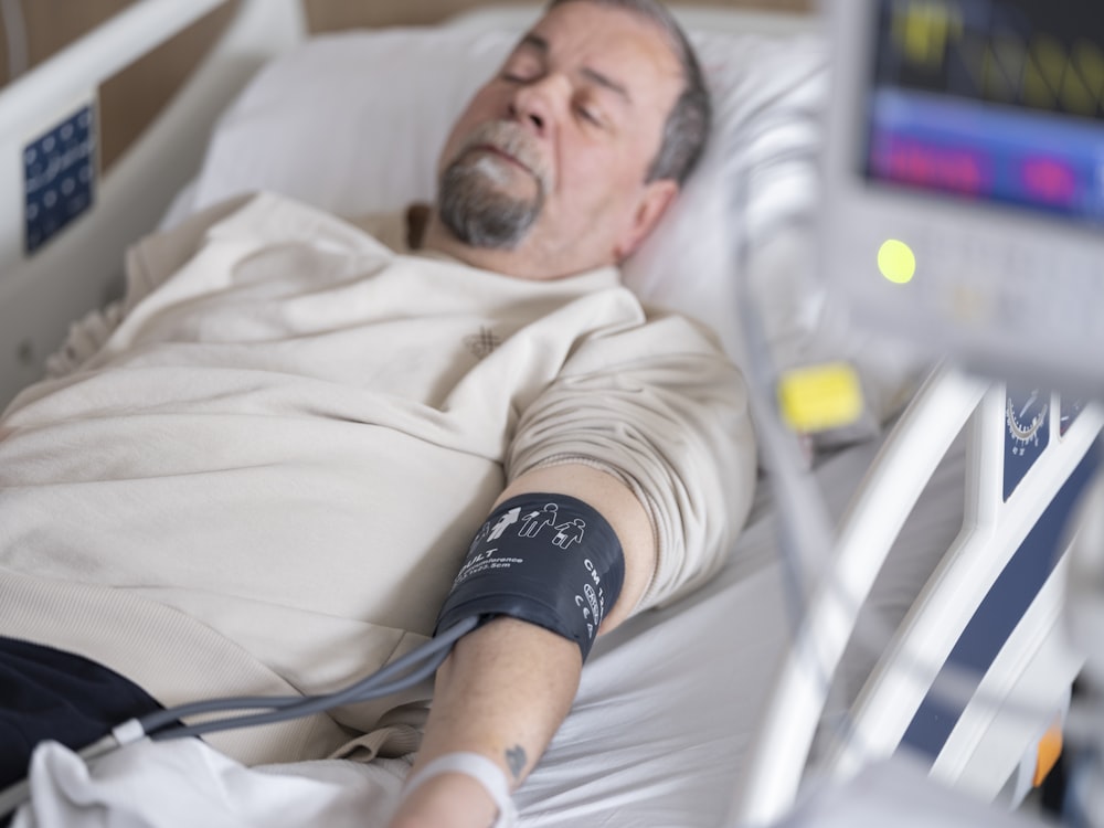 a man laying in a hospital bed with an iv