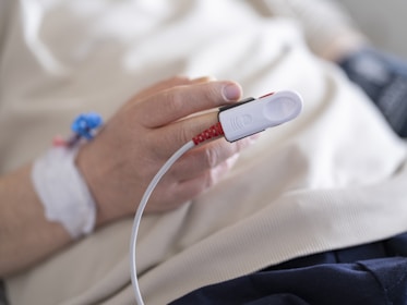 a person in a hospital bed holding a device