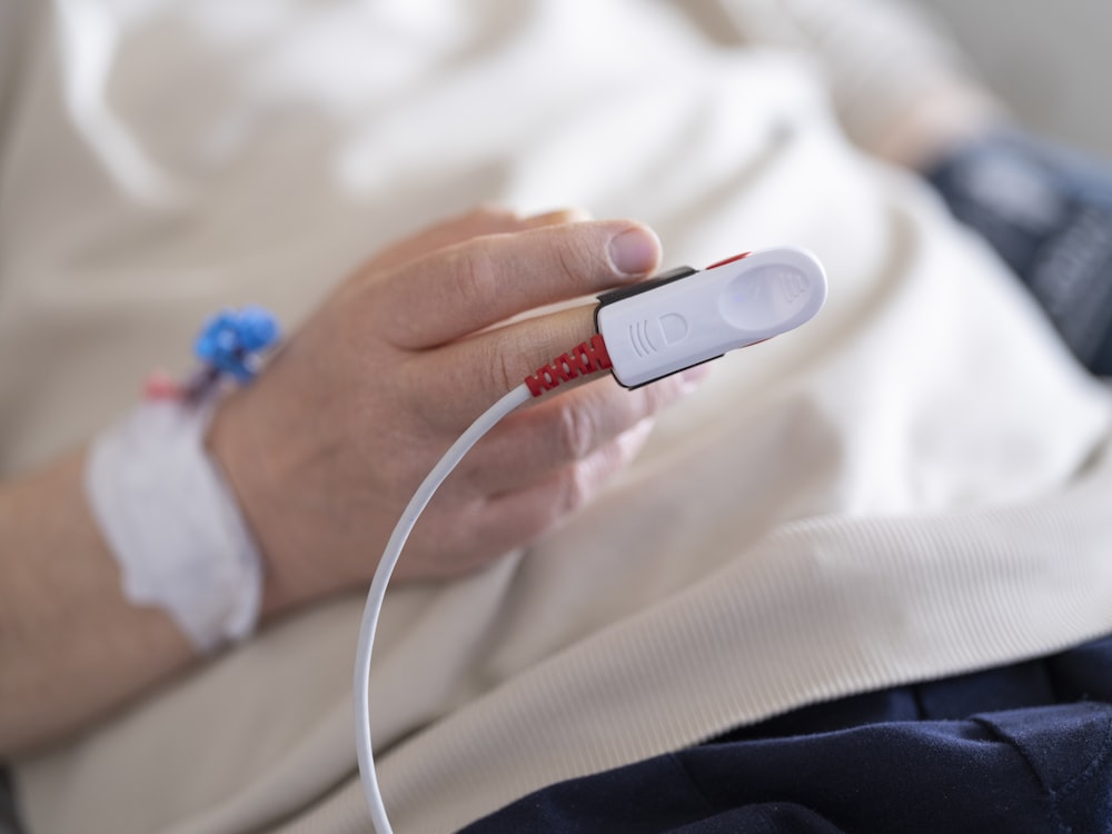 a person in a hospital bed holding a device