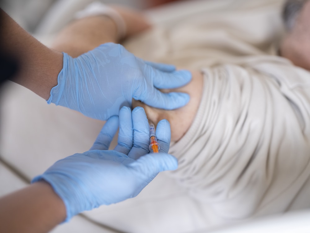 a person in a hospital bed getting an injection