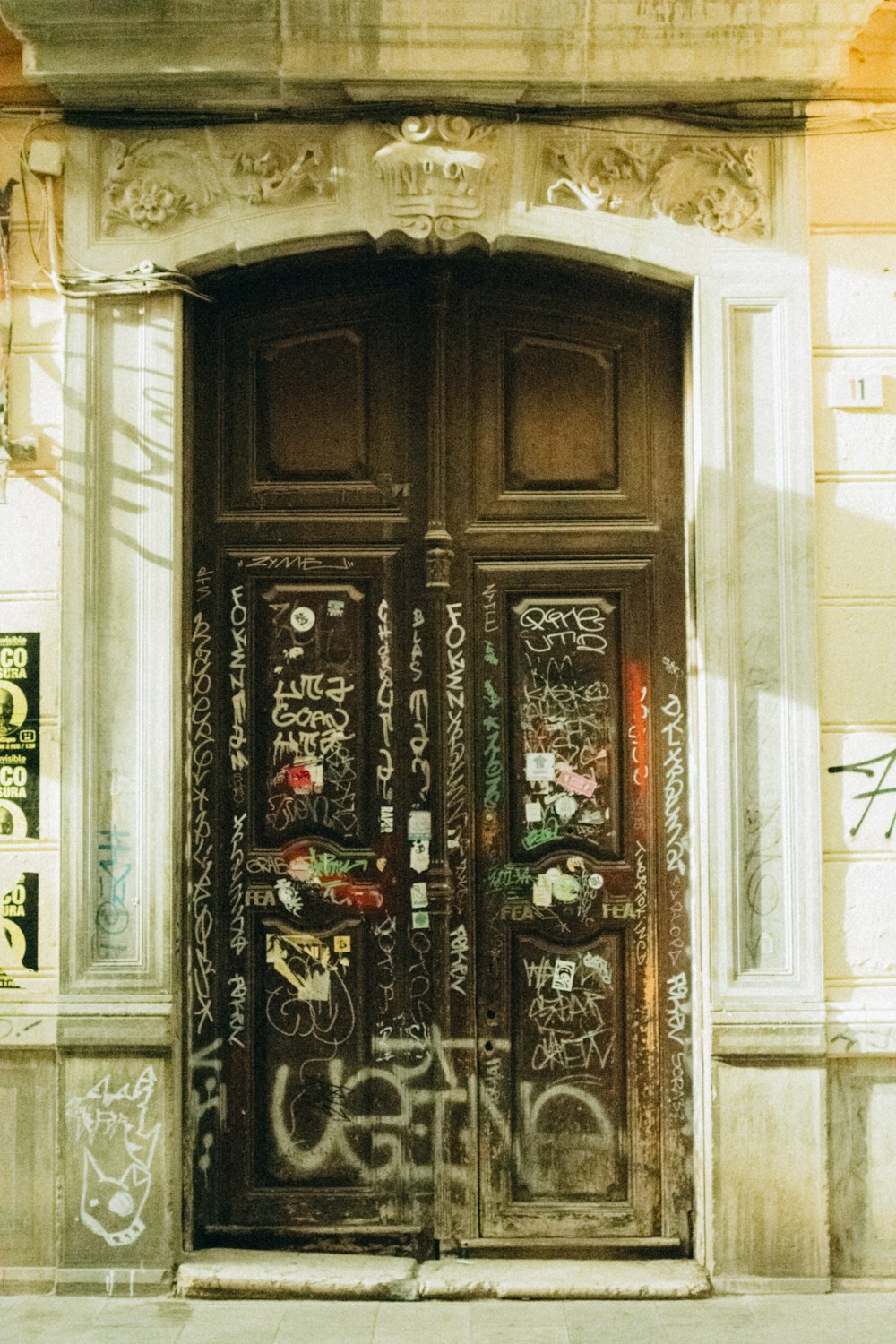 a large wooden door with graffiti all over it