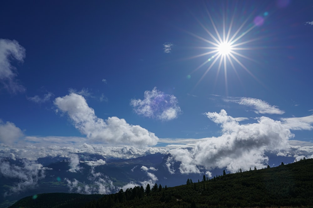 the sun shines brightly above the clouds in the sky