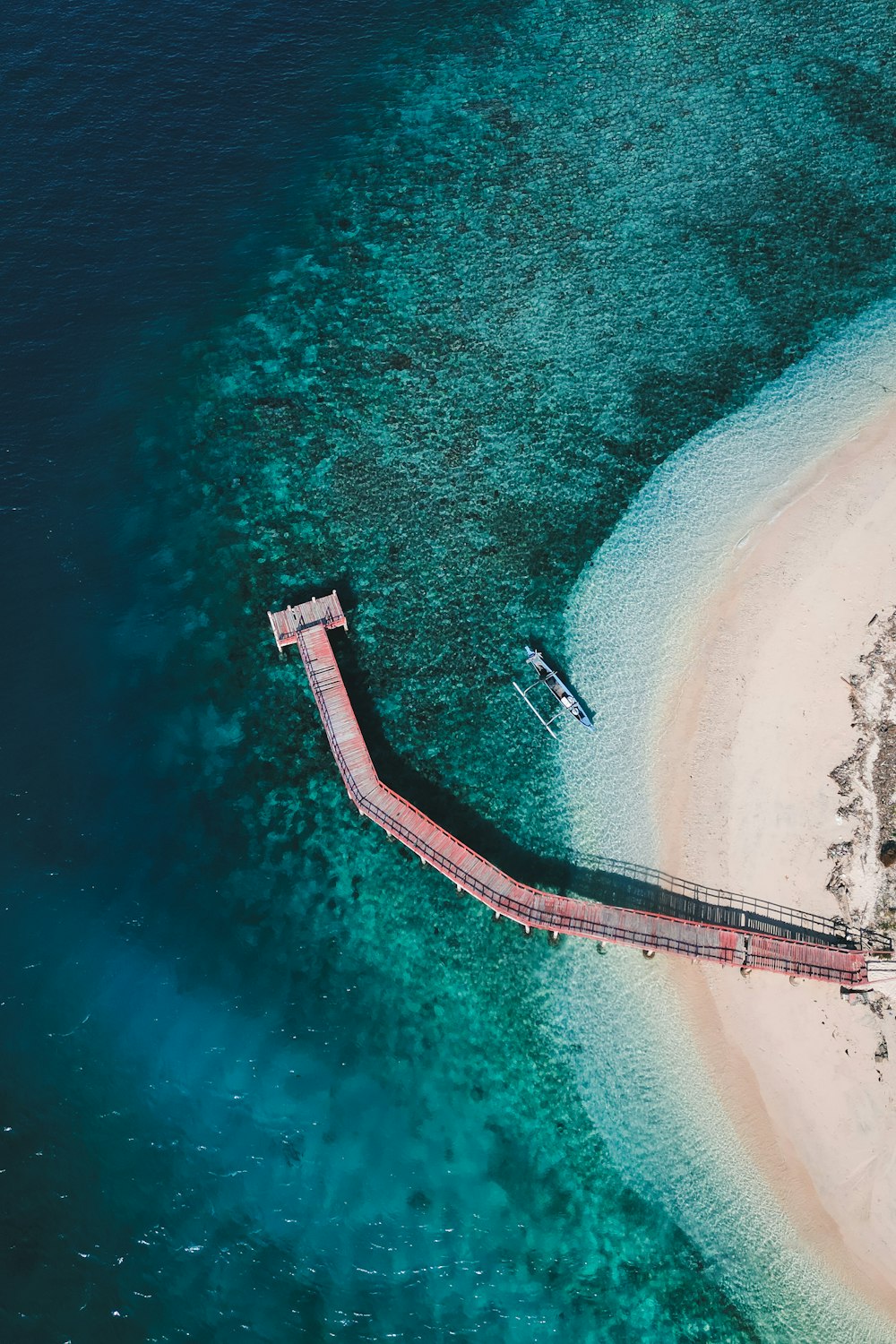 an aerial view of a pier on a beach