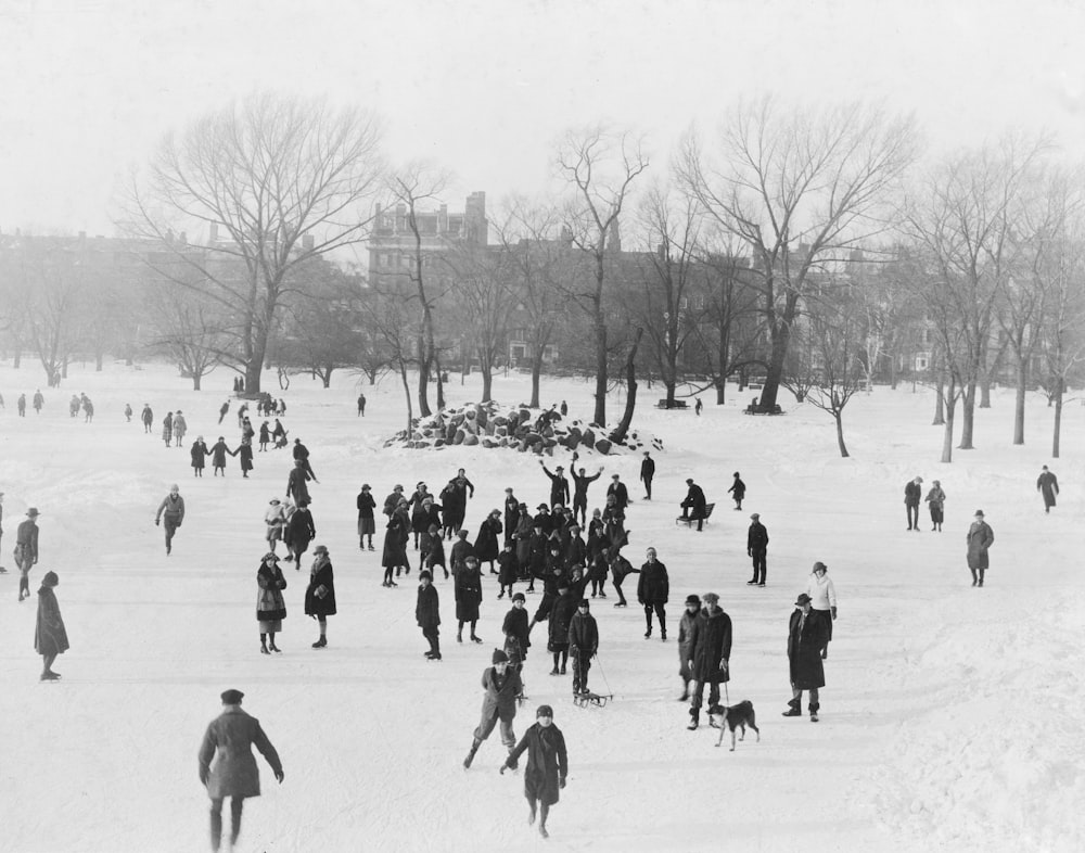 a crowd of people walking across a snow covered field