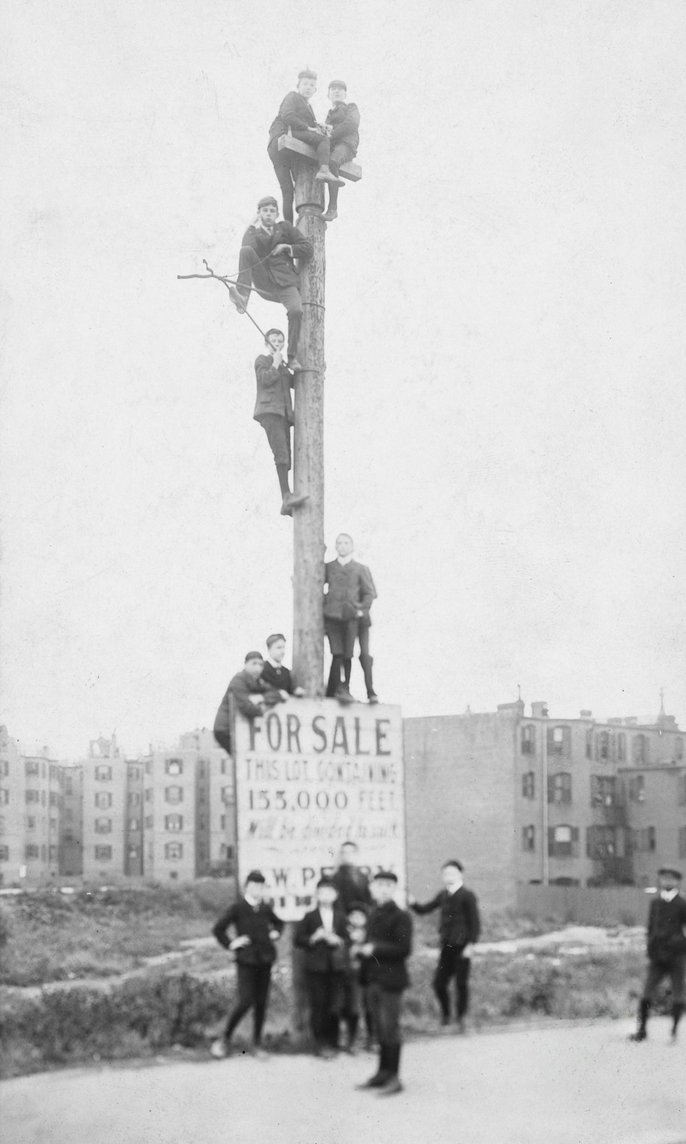a group of men standing on top of a wooden pole