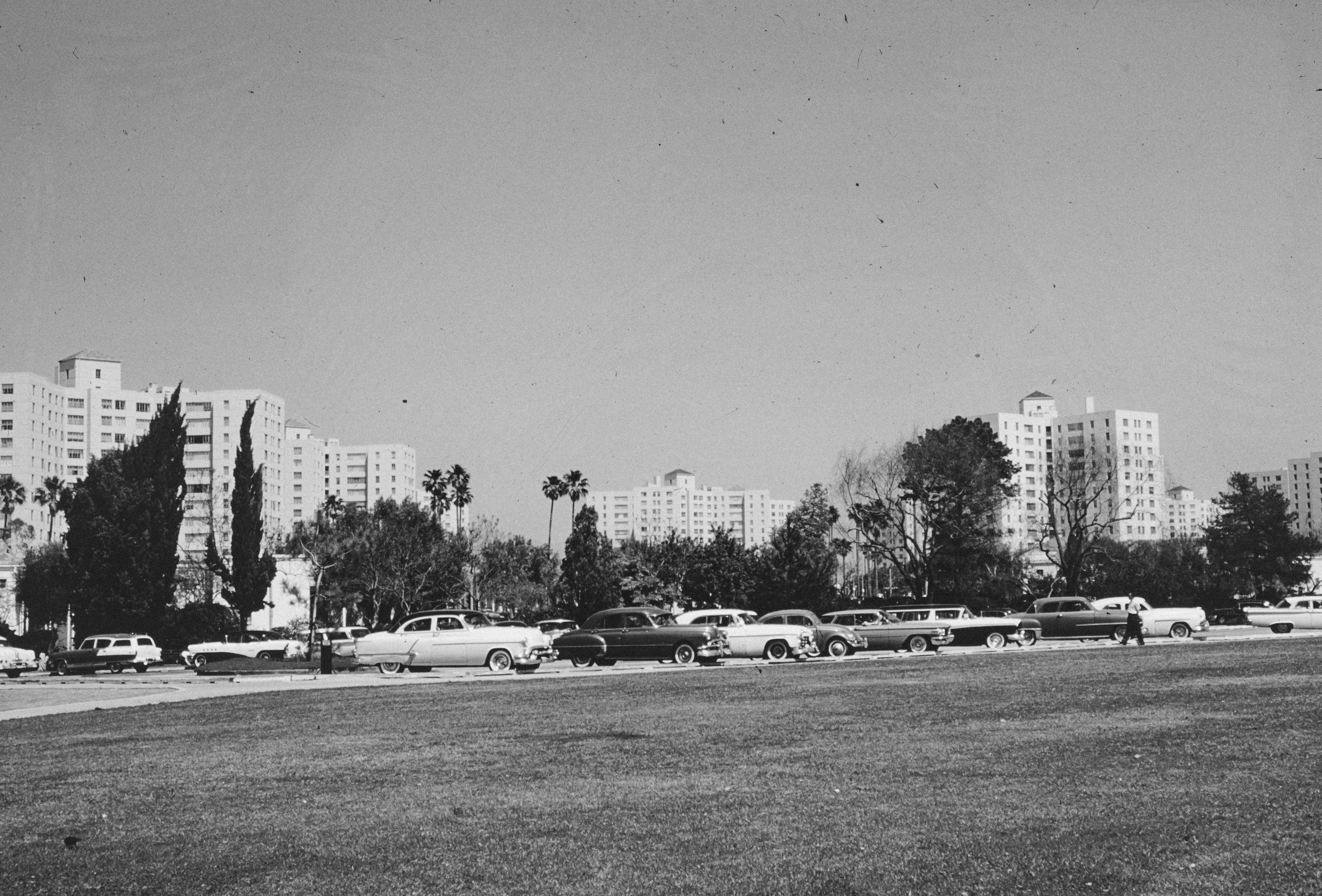 a black and white photo of cars parked in a parking lot
