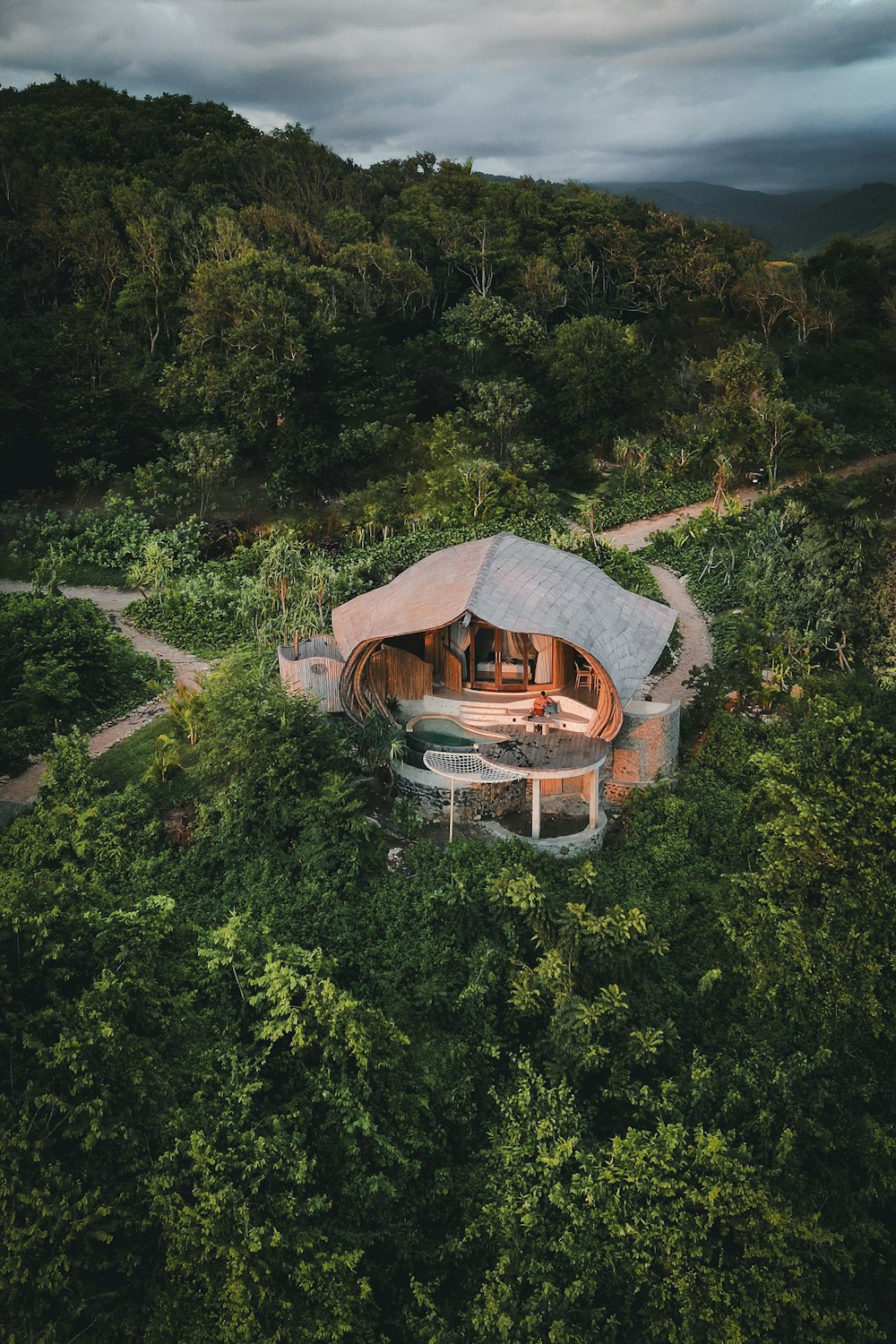 an aerial view of a house in the middle of a forest