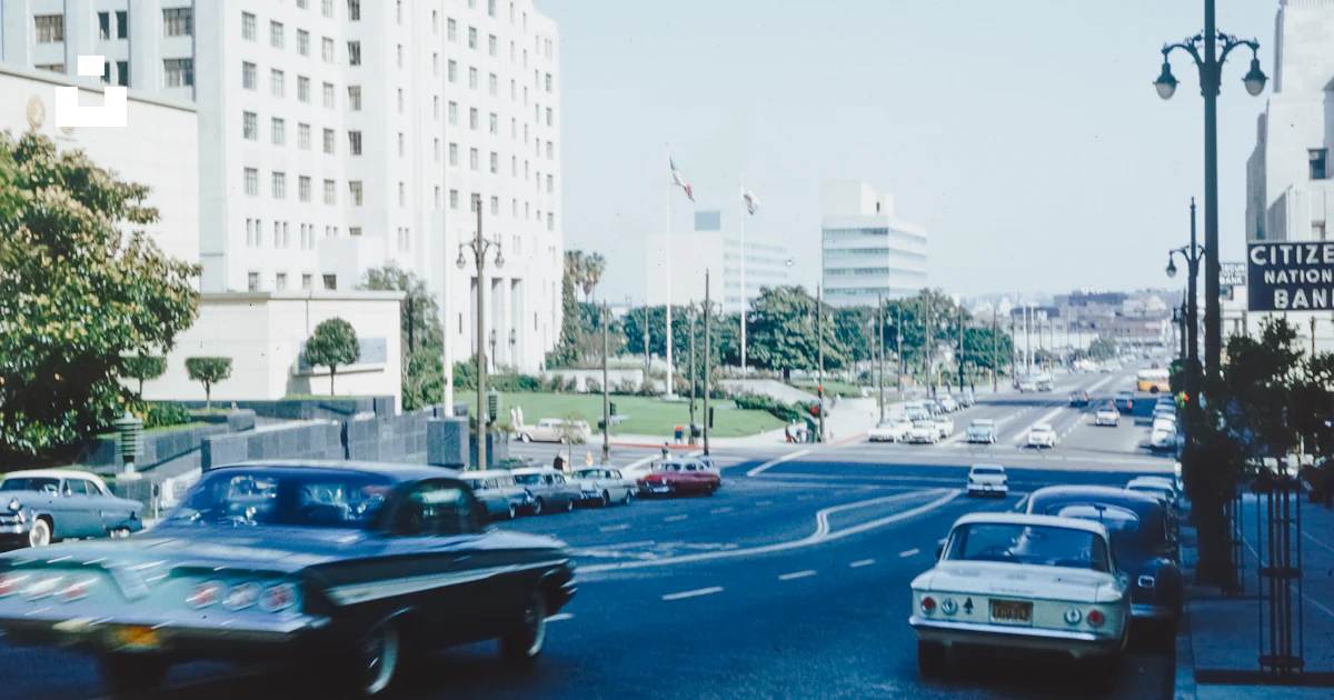 A street filled with lots of traffic next to tall buildings photo ...