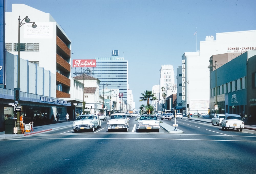 a city street filled with lots of traffic next to tall buildings