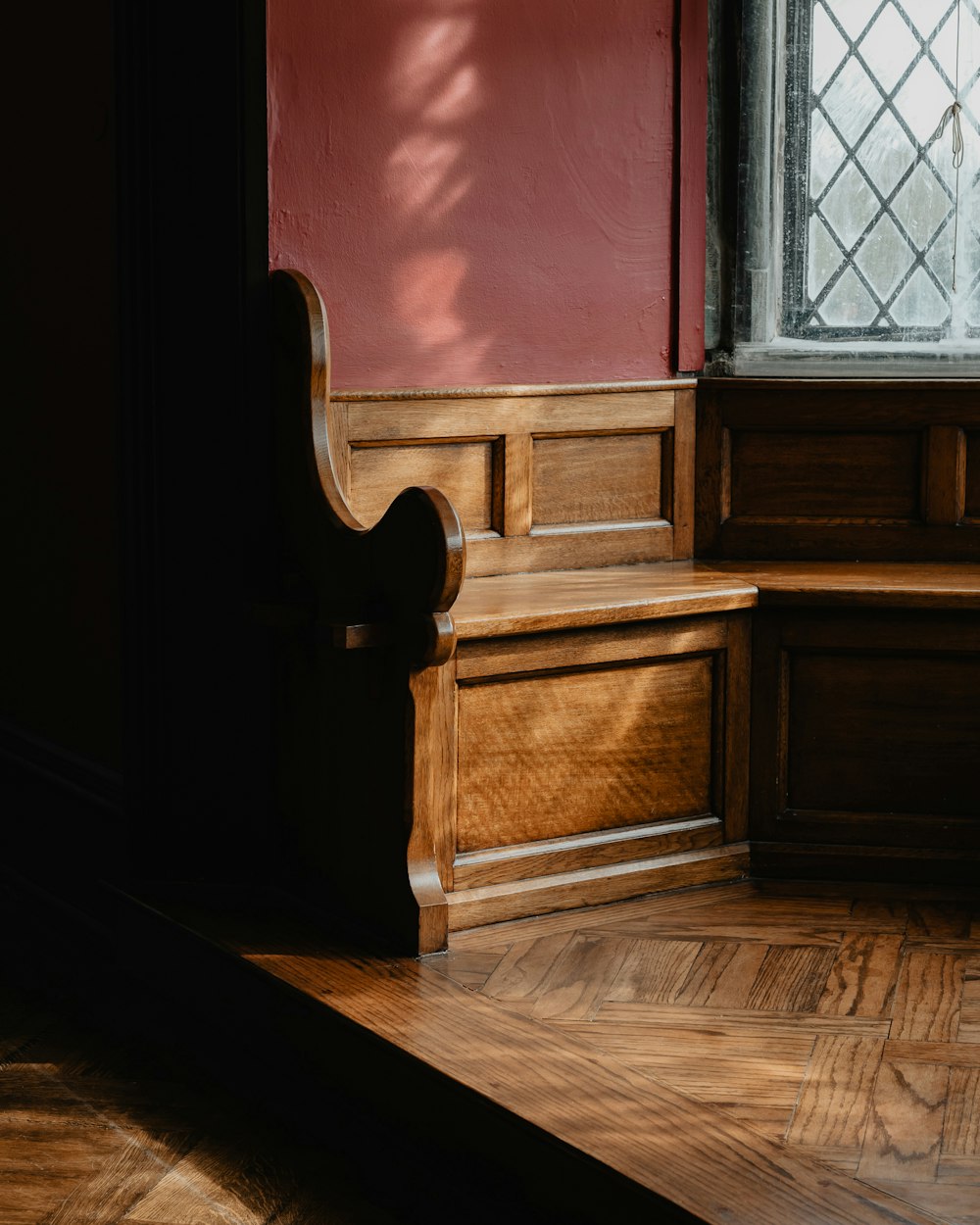 a wooden bench sitting in front of a window