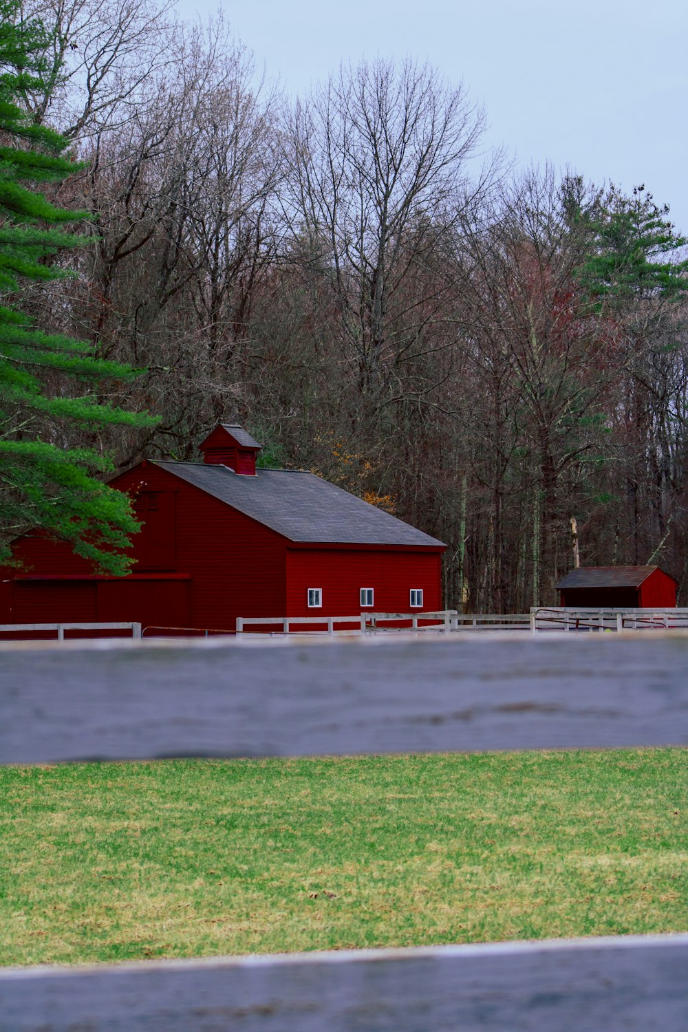a red barn with a white fence in front of it
