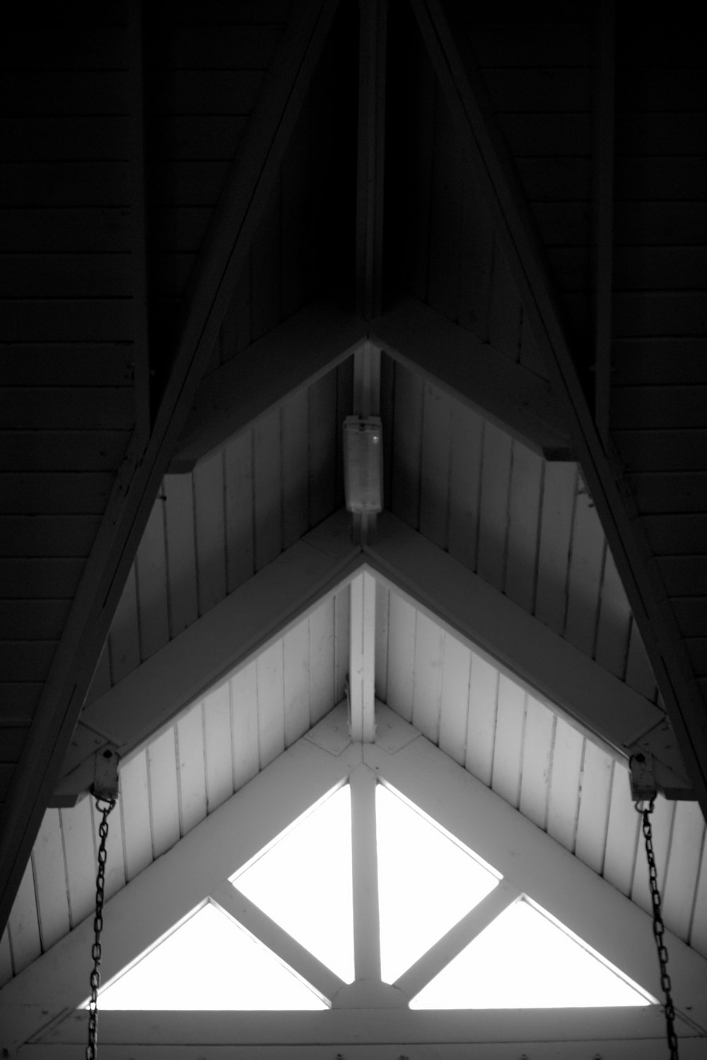 a black and white photo of a clock in a building