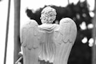 a statue of an angel holding a stick