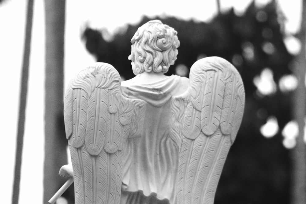 una statua di un angelo che tiene in mano un bastone