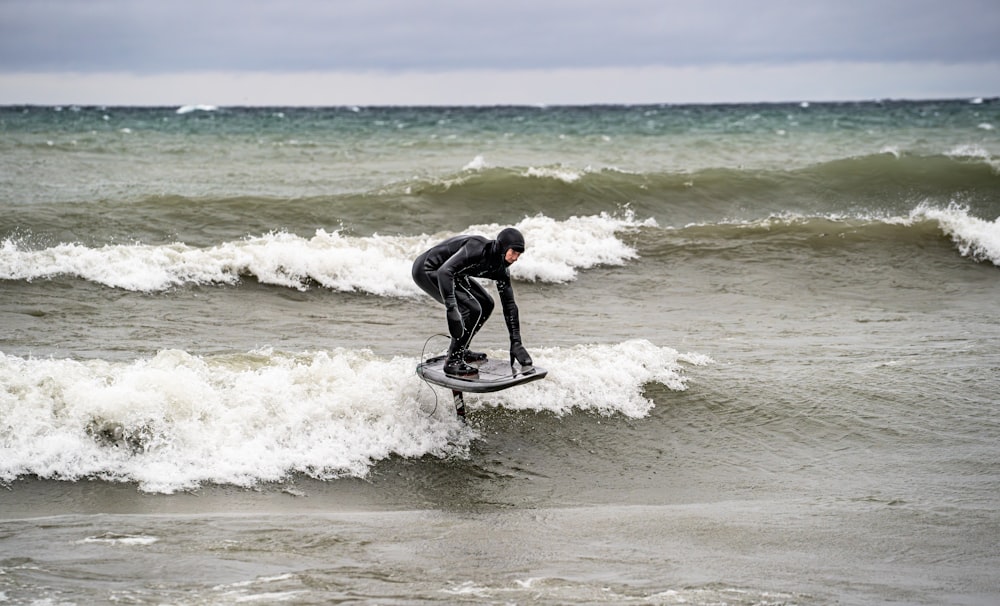 a man riding a surfboard on top of a wave