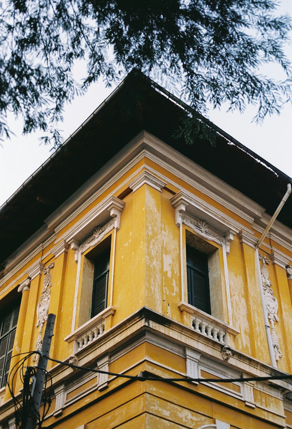 a tall yellow building with a clock on it's side