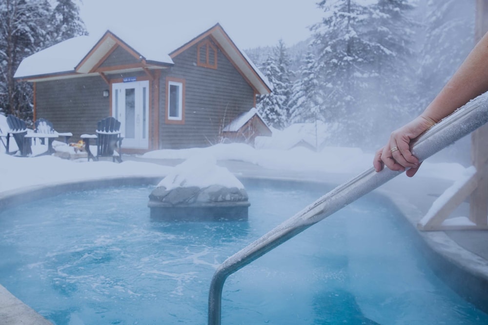 a person holding a plunger in front of a hot tub