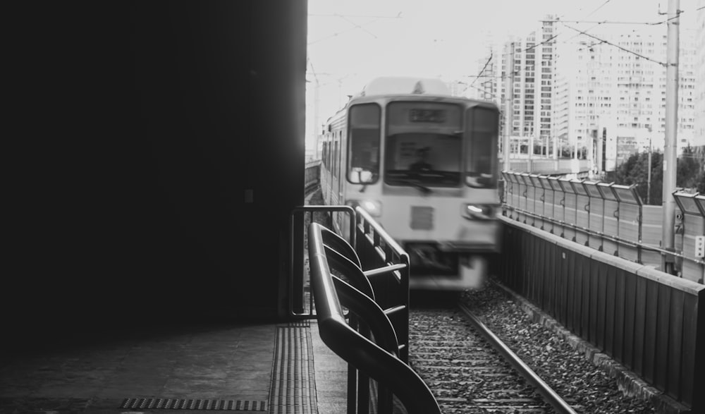 a black and white photo of a train coming down the tracks