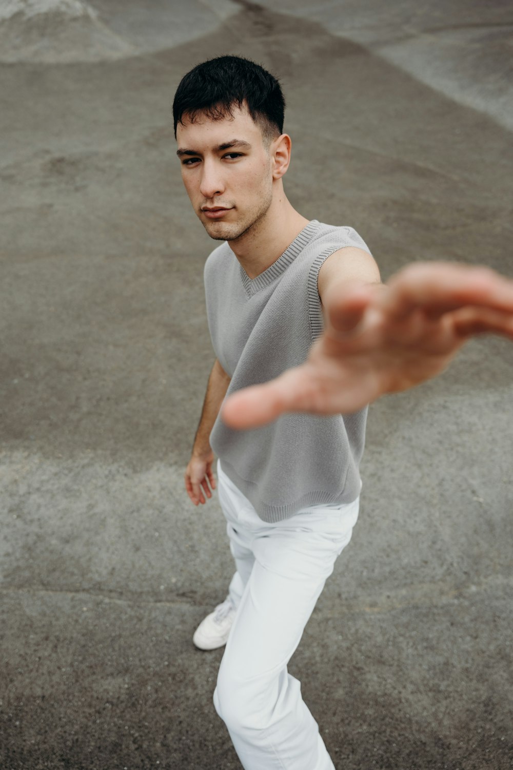 a man in a gray shirt and white pants