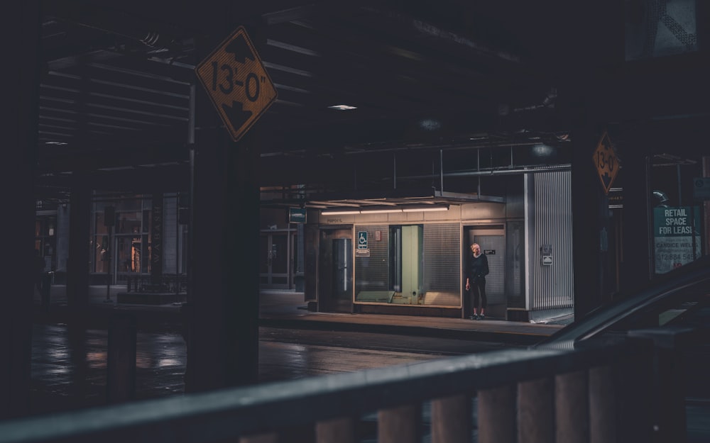 a man standing outside of a building at night