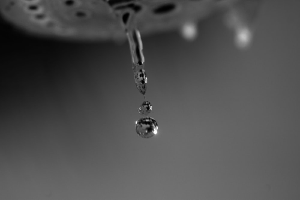 ein Wassertropfen, der an einem Wasserhahn hängt