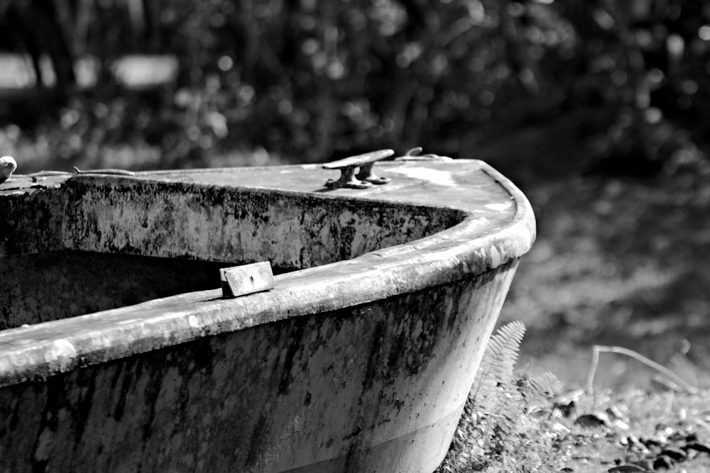 an old rusty boat sitting on the ground