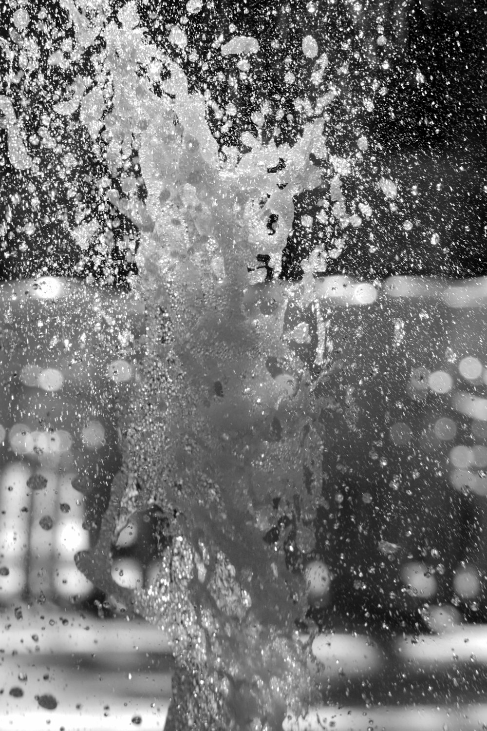 a black and white photo of a water fountain