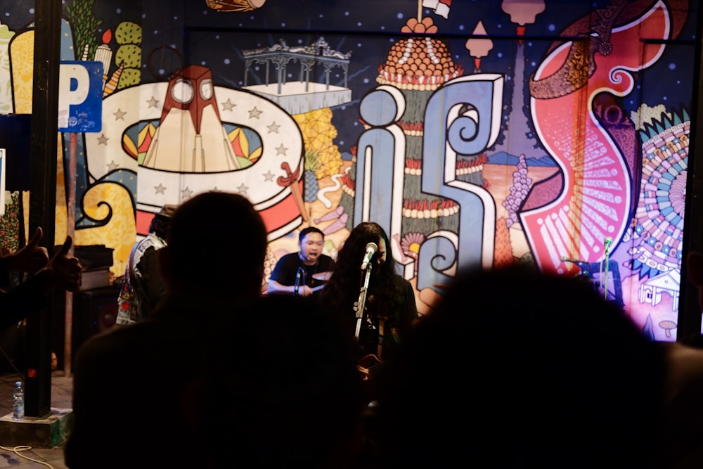 a group of people standing in front of a colorful wall