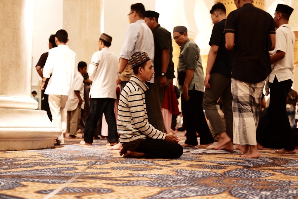 a woman sitting on the floor in front of a group of people