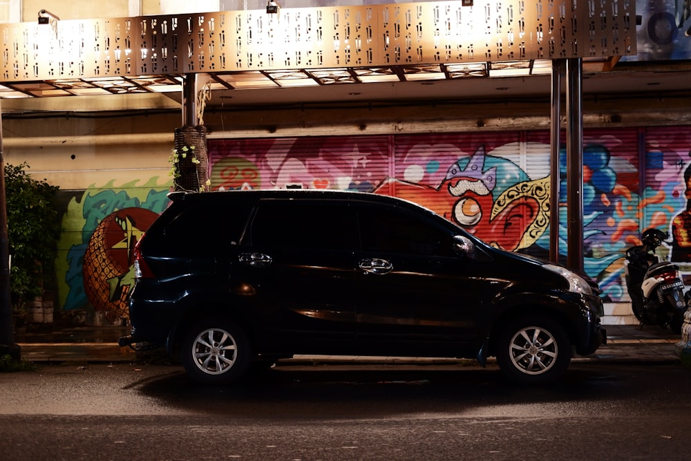 a car parked in front of a building with graffiti on it