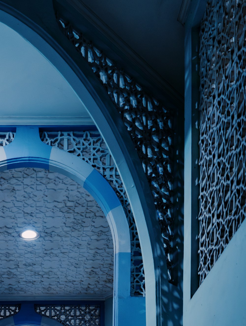 a blue and white archway with a clock on the wall