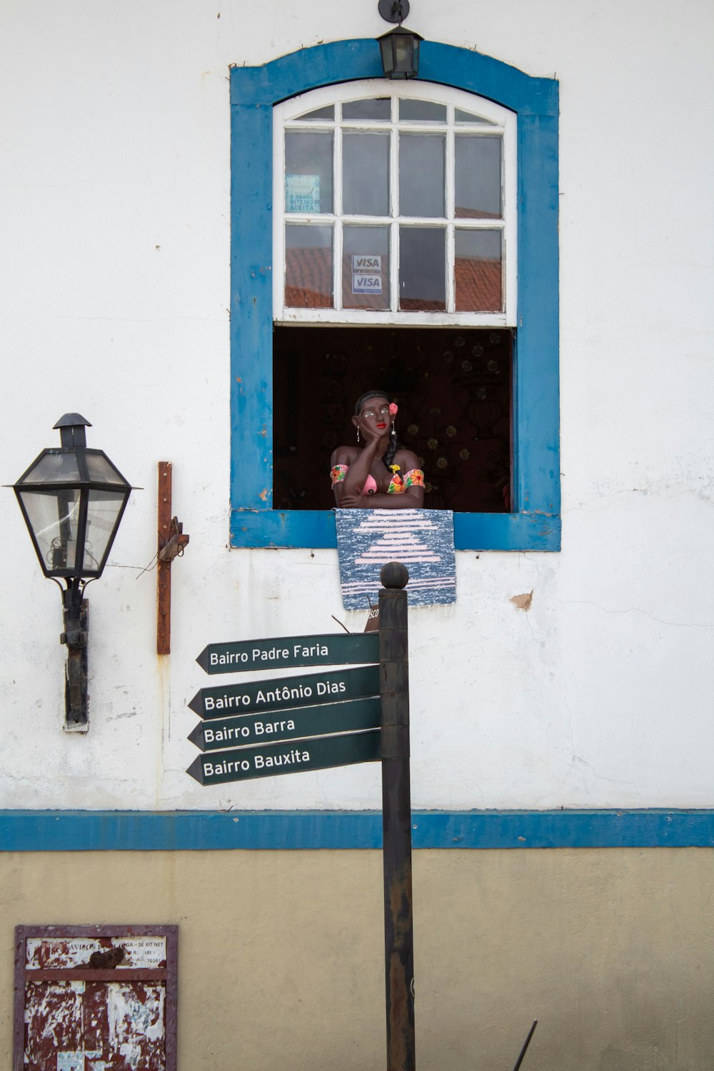 a street sign in front of a building with a blue window