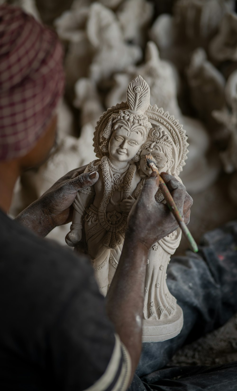 a man painting a statue with a brush