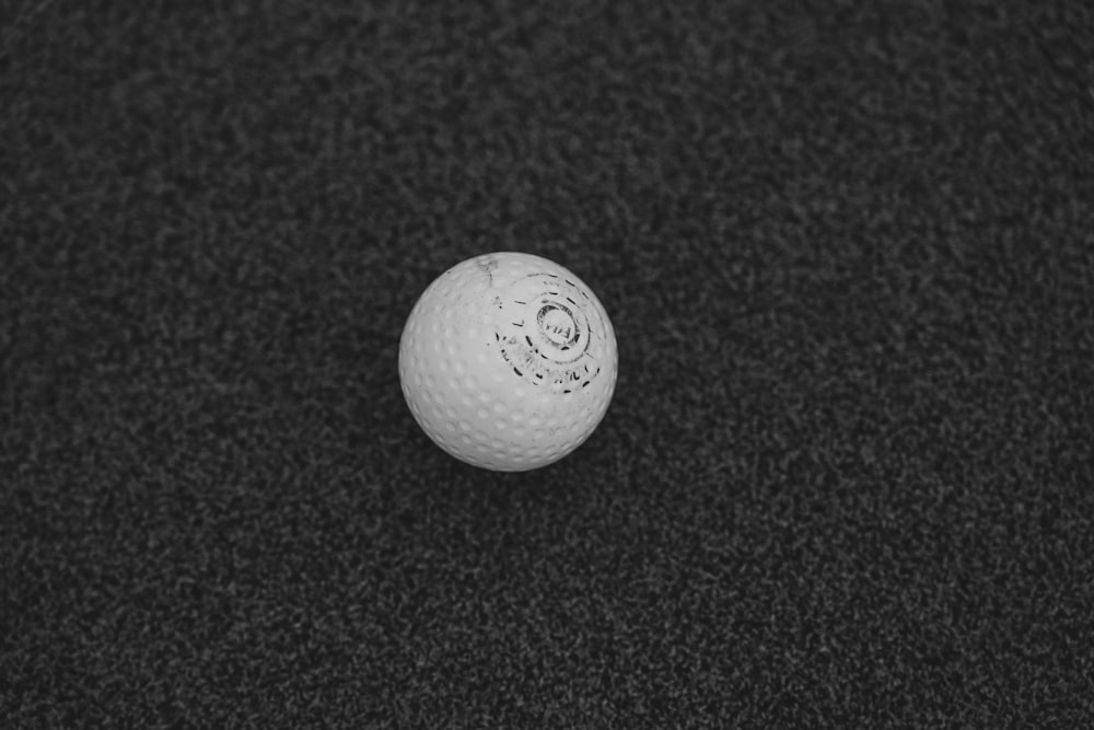 a white golf ball on a black surface