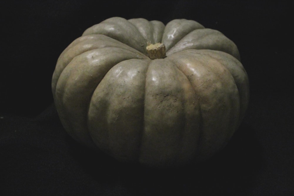 a white pumpkin sitting on top of a black table