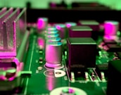 a close up of a computer motherboard with pink lights