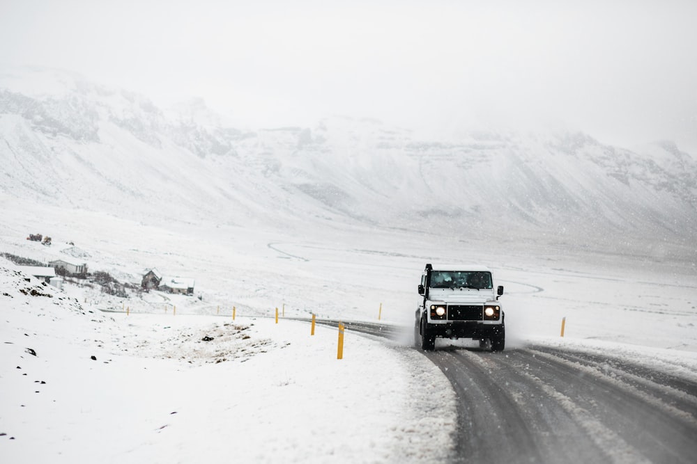 a truck driving down a snow covered road